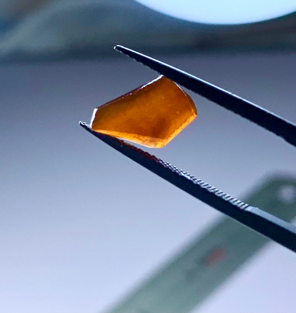 orangish brown hassonite garnet in rough shape