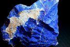 A raw blue lapis lazuli crystal specimen with prominent golden pyrite inclusions and beige matrix